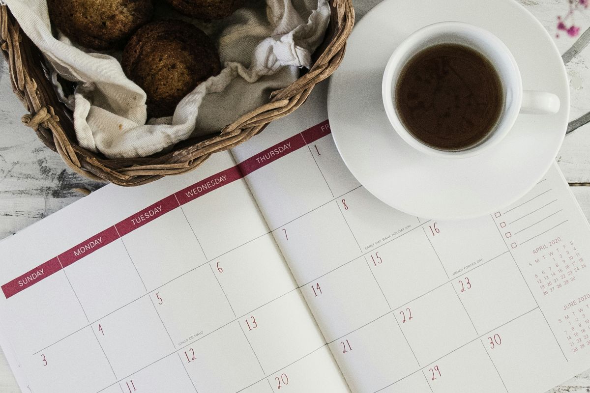 Coffee, muffins, and calendar on a table.