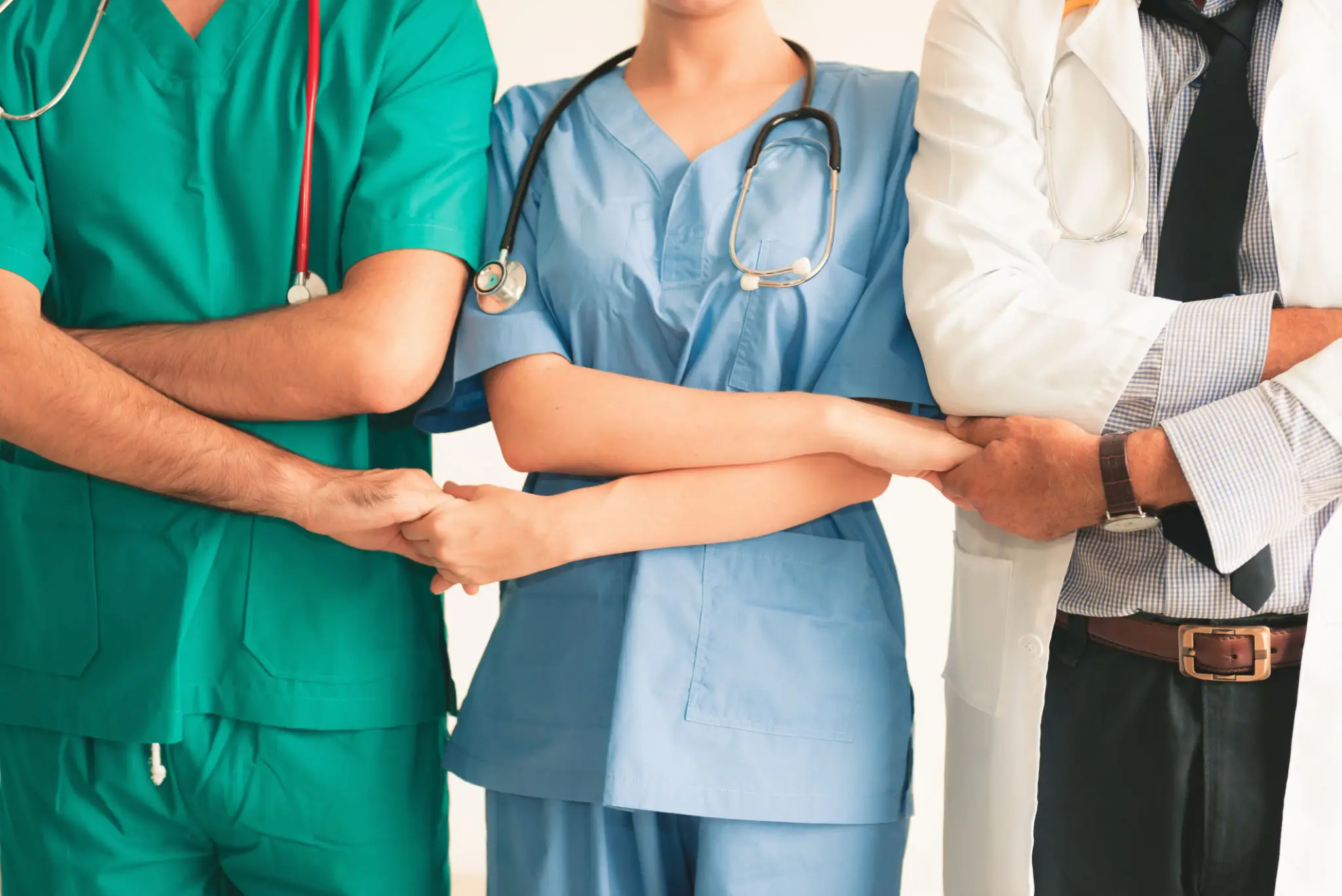 Healthcare professionals standing with arms linked.