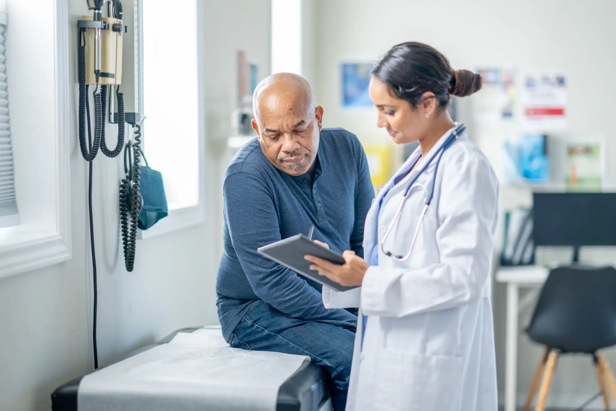Doctor consulting patient in examination room.