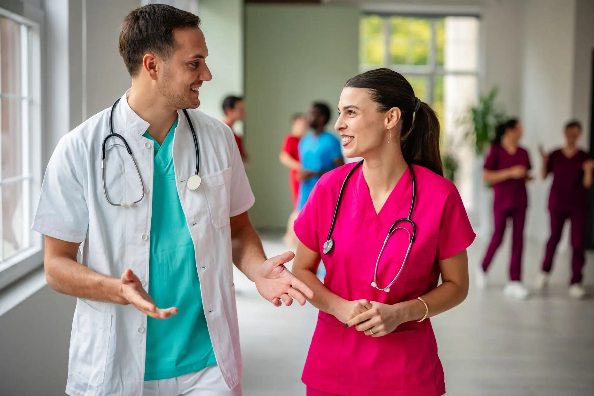 Doctors conversing in a hospital corridor.