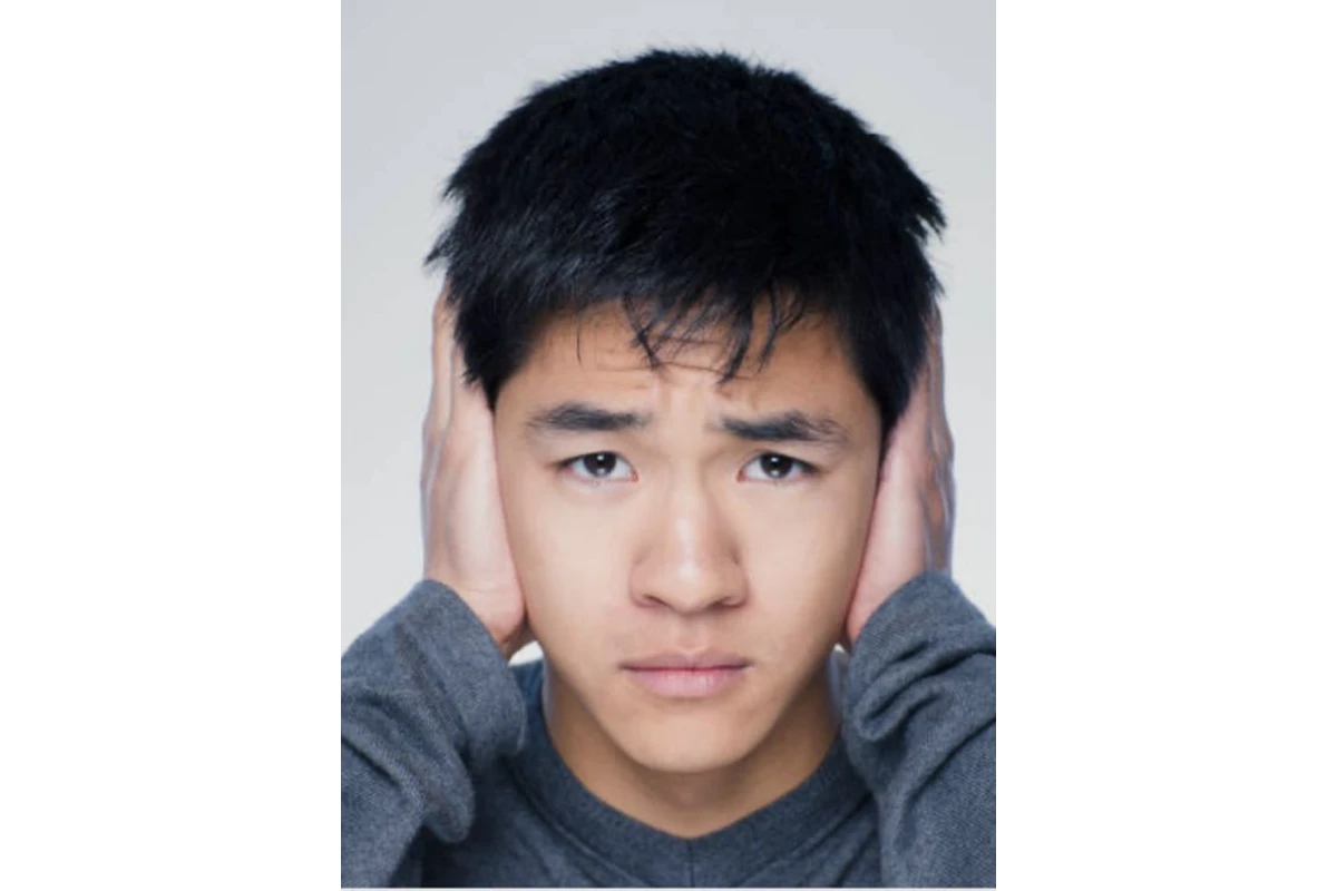 Person covering ears with both hands.