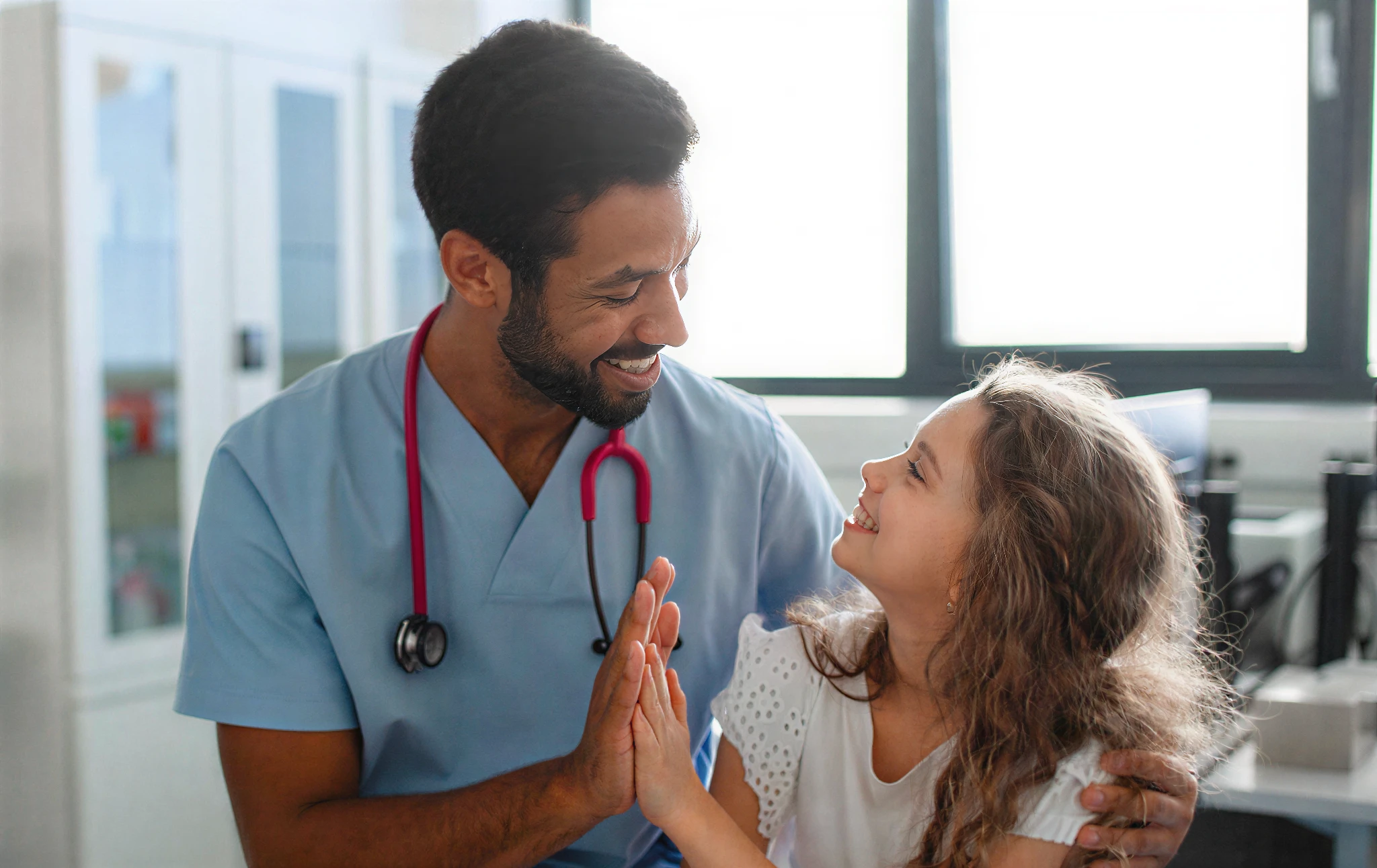 Doctor and child smiling in medical office.