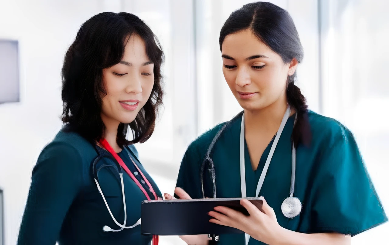 Two healthcare professionals reviewing a tablet.